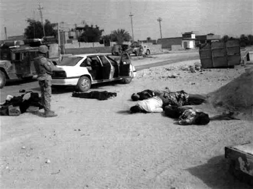 A soldier stands near bodies on the ground beside a white car